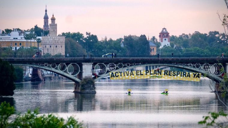 'REinventa Sevilla': Escaladores de Greenpeace se descuelgan con una pancarta en el puente de Triana